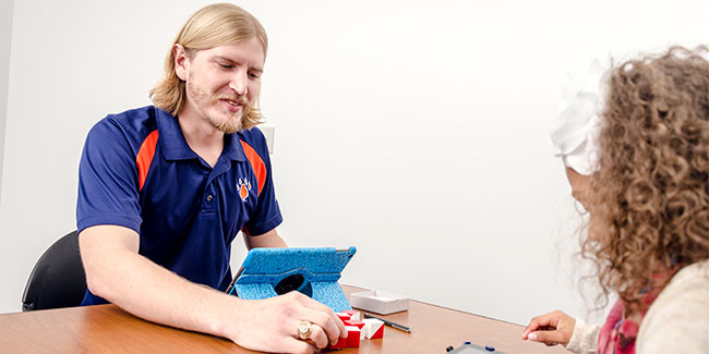 An SHSU psychologist works with a little girl by playing with blocks.