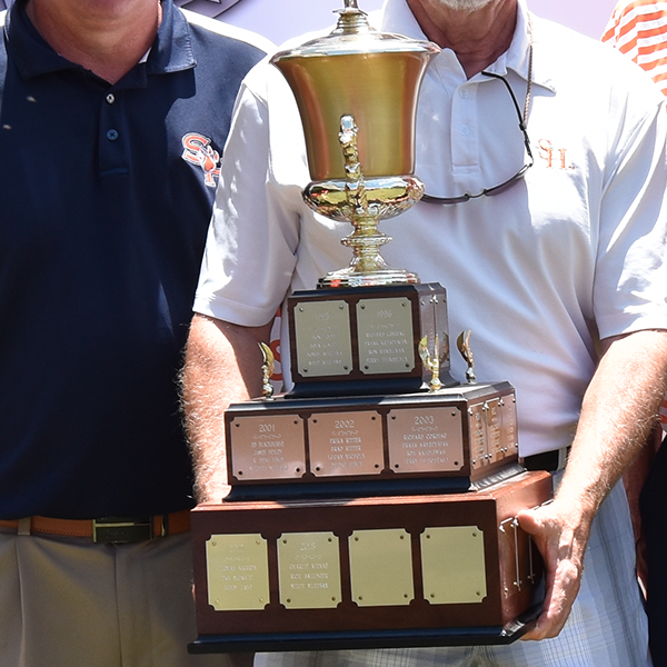 Person with SHSU polo holding a large trophy.