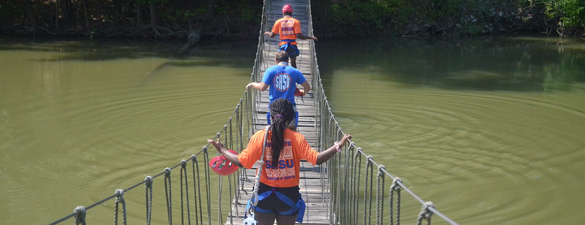 campers cross camp bridge