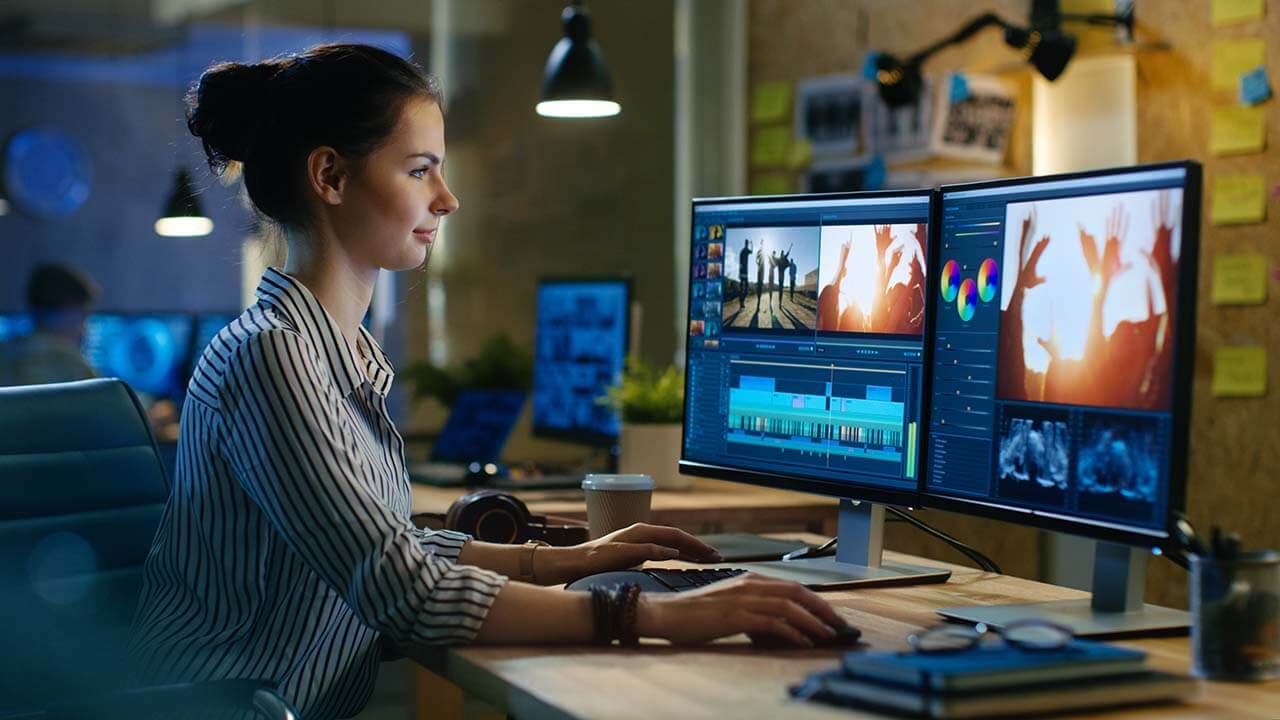 A student editing video on a computer.