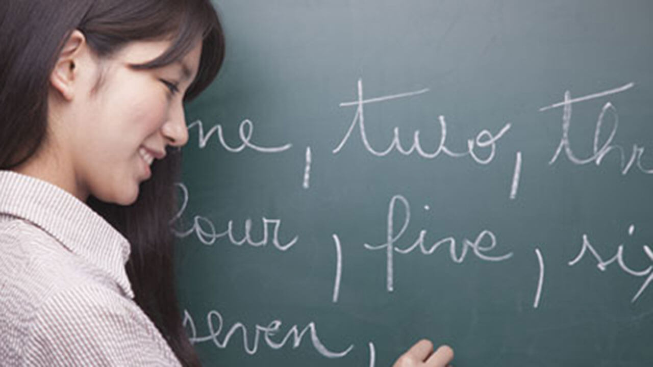 Teacher writing words on a chalboard