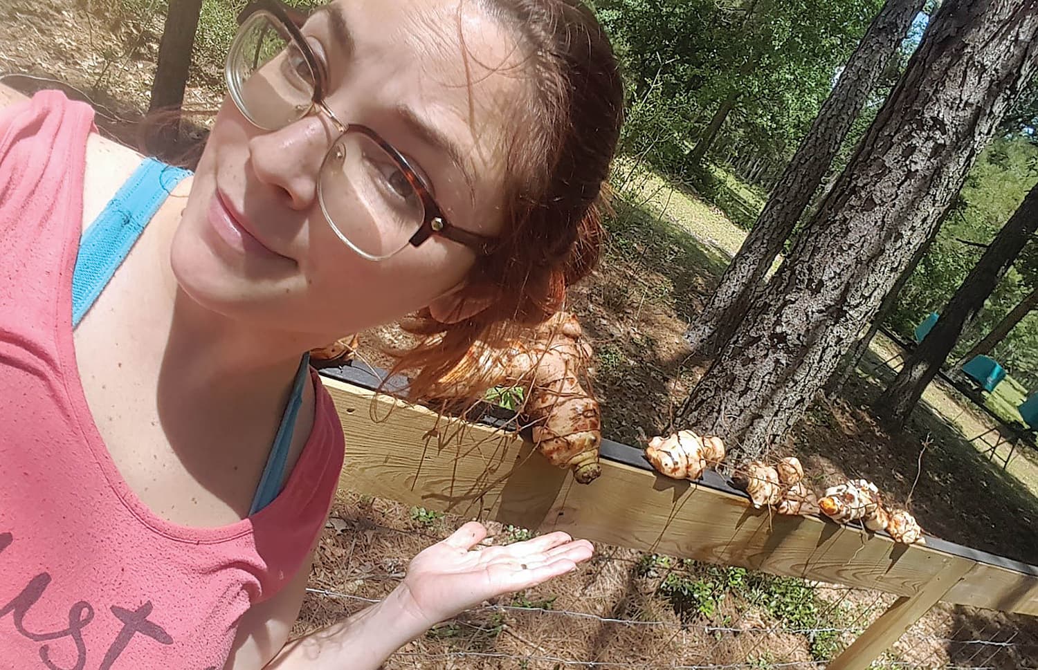 Lacey Lyde showcases her root vegetables as they sit on a fence behind her.