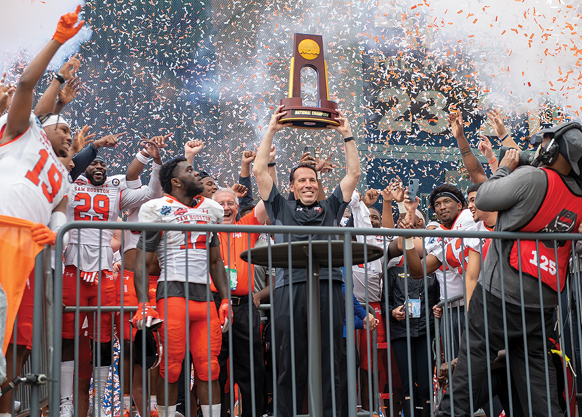 Coach K.C. Keeler holding up the championship trophy after winning the championship game.