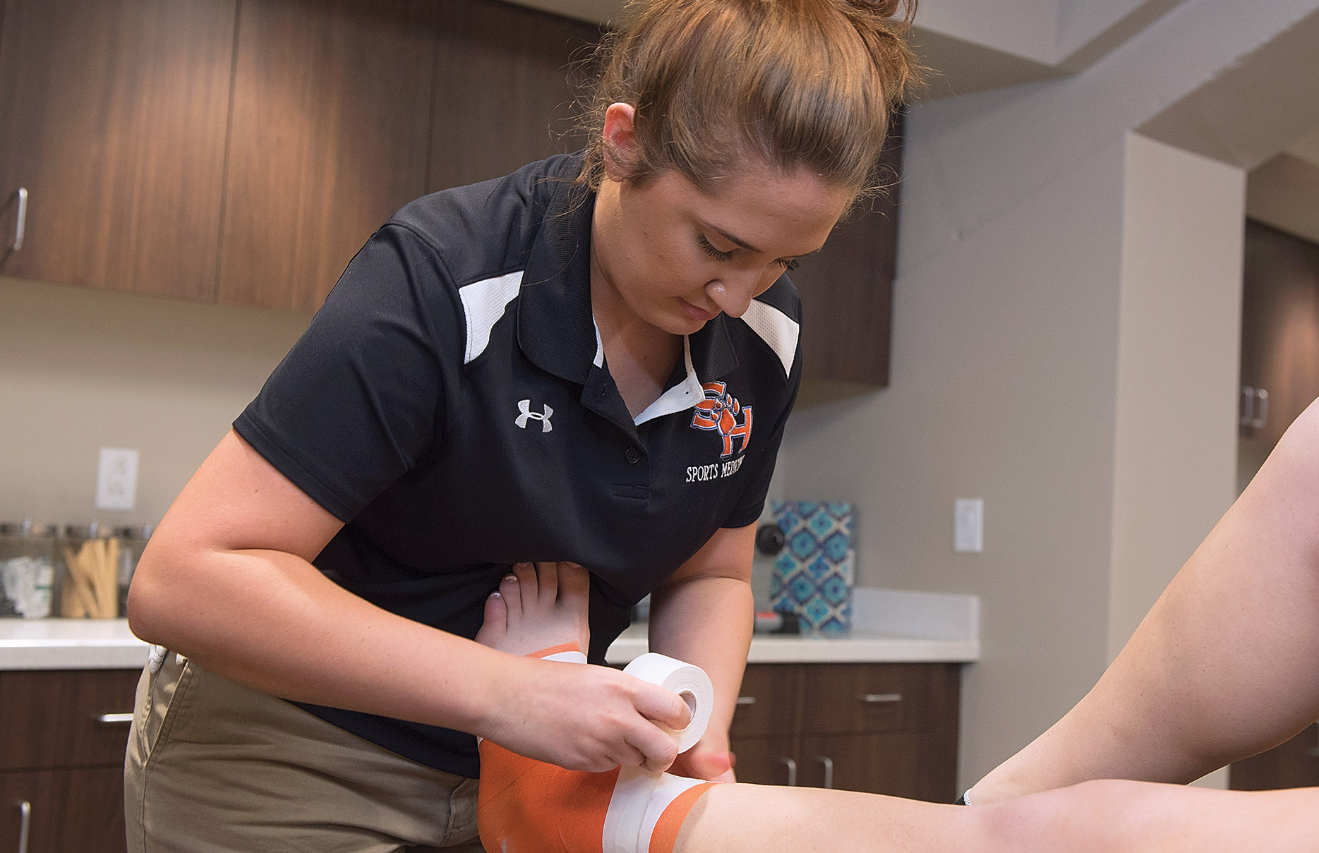 Sports medicine student attending to an injured foot